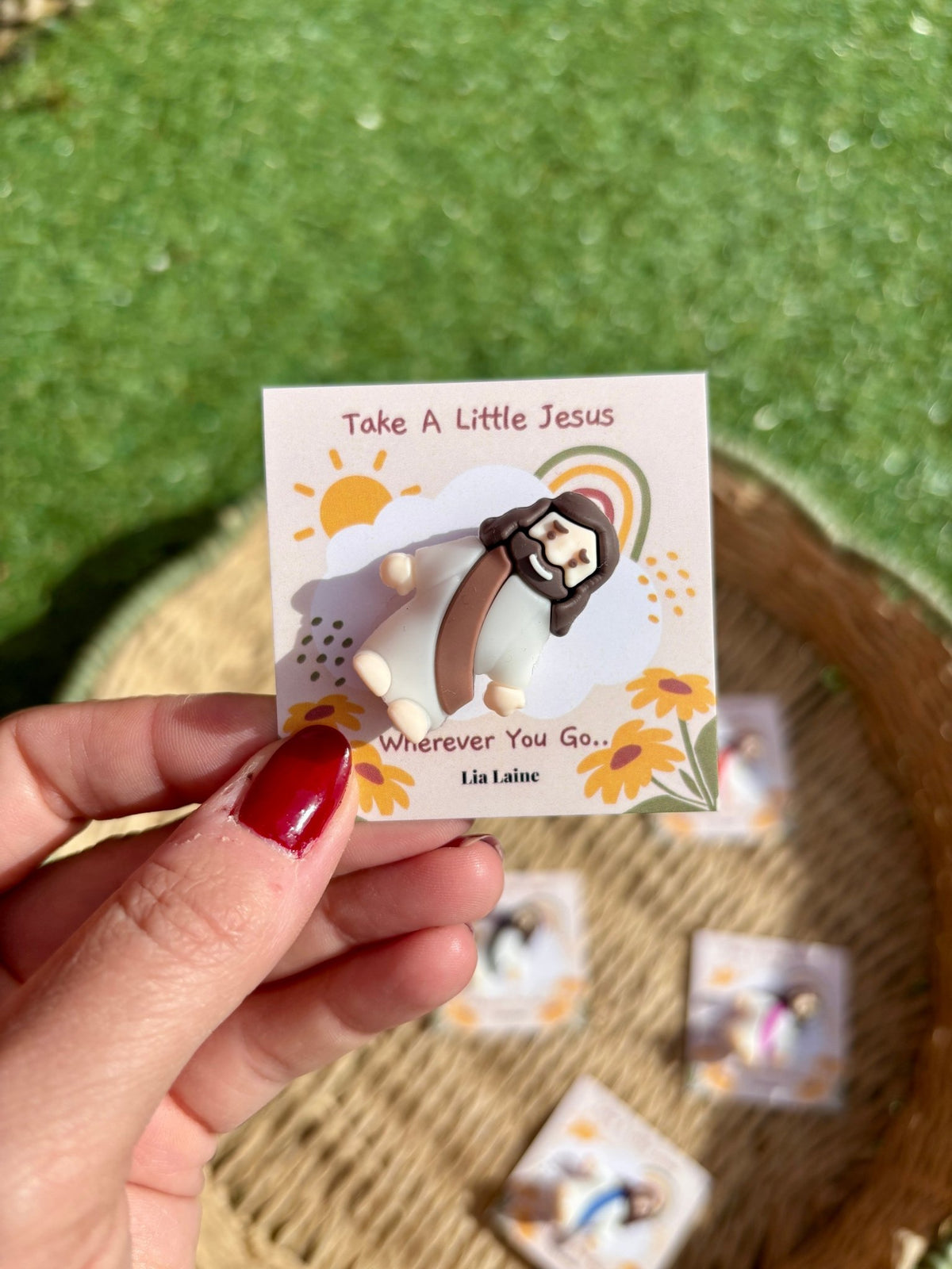 Jesus Pocket Card, brown mini Jesus figurine on a sun and rainbow backing card with other colours and grass in the background